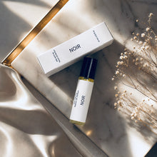 Load image into Gallery viewer, NOIR perfume oil by Maison de Parfum with matching box, styled on white marble with champagne satin, golden light, and delicate dried flowers for a sophisticated luxury editorial look.