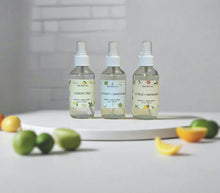 Load image into Gallery viewer, Citrus collection room sprays including Lemon Tree, Citrus & Mandarin, and Coconut + Lemongrass displayed with fresh citrus fruits on a white background.