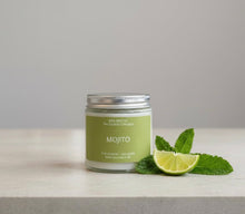 Load image into Gallery viewer, Candle labeled 'Mojito' with a lime wedge and mint leaves on a light surface.