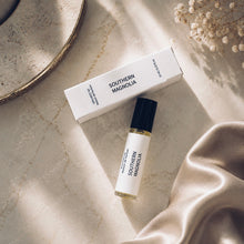 Load image into Gallery viewer, Southern Magnolia perfume oil by Maison de Parfume collection set with a white rollerball bottle, its matching white box, and styled on a marble surface with satin fabric and dried flowers.