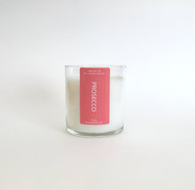 Load image into Gallery viewer, Prosecco natural wax candle with a red label on a white background, hand-poured in Wilmington, North Carolina.