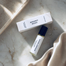 Load image into Gallery viewer, A Bergamot Woods perfume oil by Maison de Parfum with a white matching box, styled on a light marble surface with draped satin fabric.
