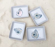Load image into Gallery viewer, Four small white dishes with oyster designs on a sandy background
