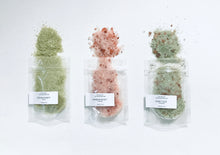 Load image into Gallery viewer, Three sample bath salts pouches with mineral salts spilled on a white background.
