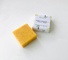 Load image into Gallery viewer, Sweet orange and poppy seeds soap bar with its packing displayed on a soft white surface. 
