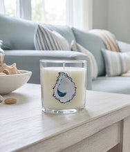Load image into Gallery viewer, Glass candle with a decorative design on a wooden surface in a cozy living room.
