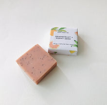 Load image into Gallery viewer, Grapefruit and poppy seeds soap bar with its packing displayed on a clean white surface.
